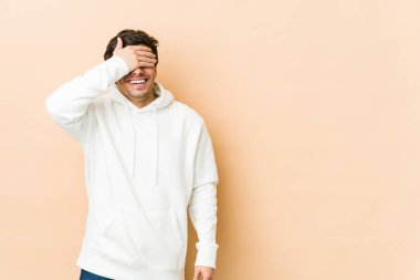 Genç, havalı adam elleriyle gözlerini kapatıyor, gülümseyerek bir sürpriz bekliyor..