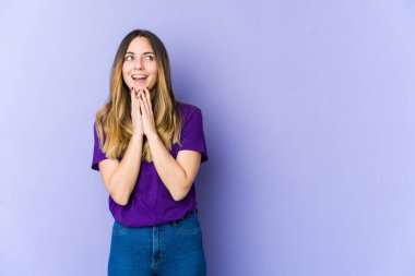 Kafkasyalı genç bir kadın mor arka planda izole edilmiş bir plan yapıyor, bir fikir kuruyor..