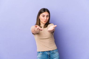 Beyaz kadın dudaklarını katlıyor ve hava öpücüğü vermek için avuçlarını tutuyor..