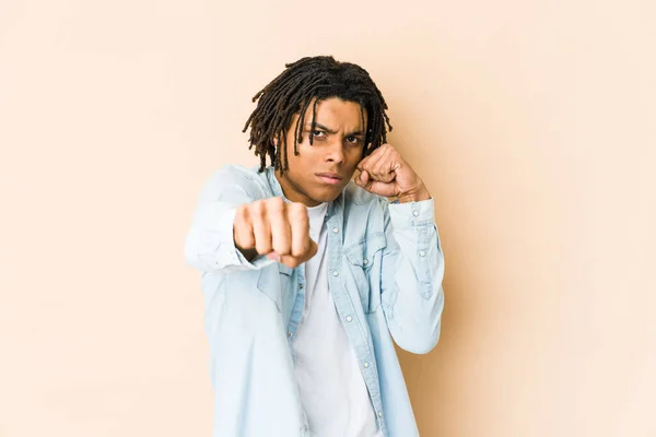 Young african american rasta man throwing a punch, anger, fighting due to an argument, boxing.