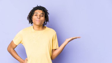 Genç Afrikalı Amerikalı Rasta adam sorgulama jesti için omuz silkiyor ve şüphe ediyor..