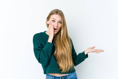 Beyaz arka planda izole edilmiş genç sarışın kadın, avuç içinde kopya alanı tutmaktan etkilenmiş..