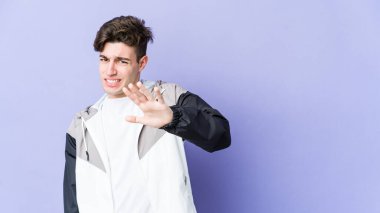 Mor arka planda izole edilmiş genç beyaz bir adam tiksinti belirtisi gösteren birini reddediyor..