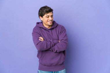 Kollarını kavuşturup kendinden emin gülümseyen genç havalı adam..