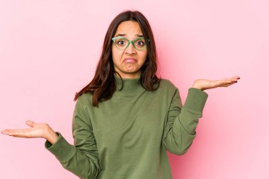 Latin kökenli genç bir kadın. Kafası karışmış ve omuz silkiyor. Kopya alanını tutmak için..