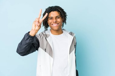 Genç Afrikalı Amerikalı sporcu zafer işareti gösteriyor ve gülümsüyor..