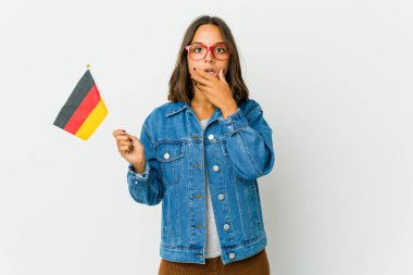 Beyaz arka planda izole edilmiş bir Alman bayrağı tutan genç Latin kadın avuç içinde fotokopi alanı tutuyor, el üstünde tutuyor. Şaşırmış ve mutlu..