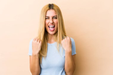 Genç sarışın, beyaz kadın, gamsız ve heyecanlı bir şekilde tezahürat yapıyor. Zafer konsepti.