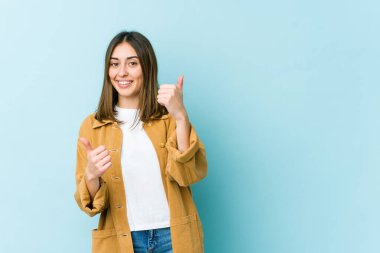 Kafkasyalı genç bir kadın iki parmağını da kaldırıyor, gülümsüyor ve kendinden emin..