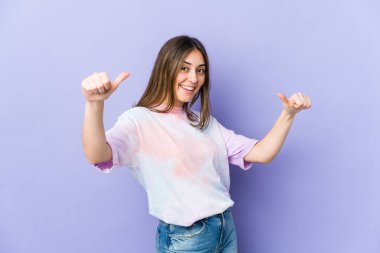 Kafkasyalı genç bir kadın iki parmağını da kaldırıyor, gülümsüyor ve kendinden emin..