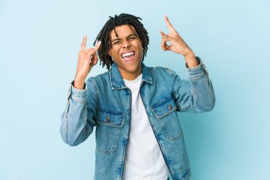 Kot pantolon giyen genç siyahi bir adam boynuzlarını devrim konsepti olarak gösteriyor..