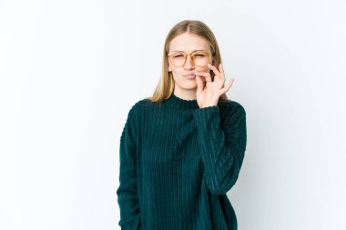 Beyaz arka planda izole edilmiş genç sarışın kadın parmakları dudaklarında bir sır saklıyor..