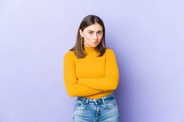 Young caucasian woman frowning face in displeasure, keeps arms folded.