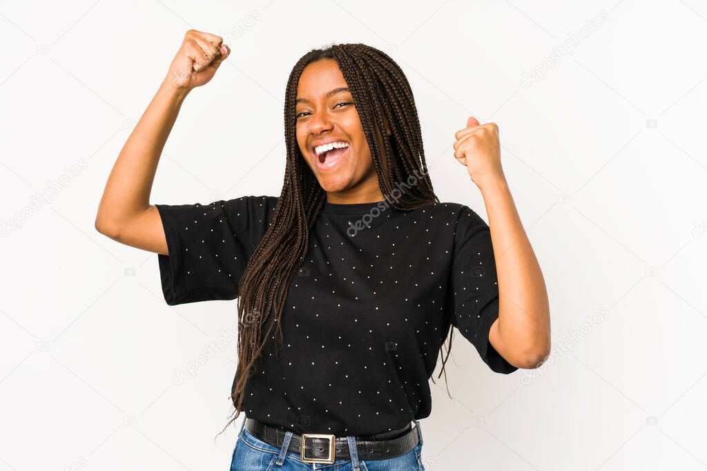 Young african american woman isolated on white background celebrating a special day, jumps and raise arms with energy.