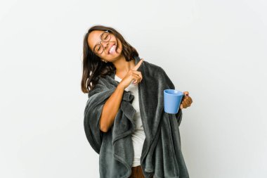 Beyaz arka planda battaniyeli genç Latin kadın dans ediyor ve eğleniyor..