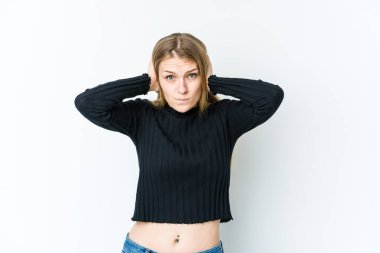 Sarışın bir kadın, beyaz arka planda izole edilmiş kulakları kulaklarıyla kapatıyor ve yüksek ses duymamaya çalışıyor..