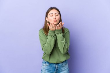 Beyaz kadın dudaklarını katlıyor ve hava öpücüğü vermek için avuçlarını tutuyor..