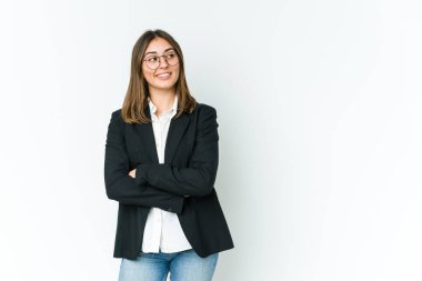 Genç beyaz iş kadını kollarını kavuşturarak gülümsüyor..