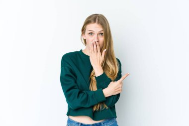 Beyaz arka planda izole edilmiş genç sarışın kadın yan tarafı gösteriyor.