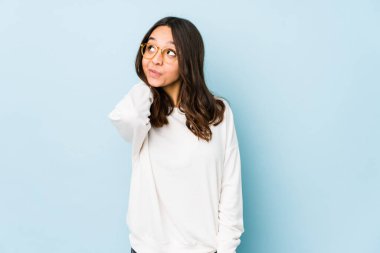 Genç, melez, İspanyol bir kadın. Kafasının arkasına dokunuyor, düşünüyor ve bir seçim yapıyor..