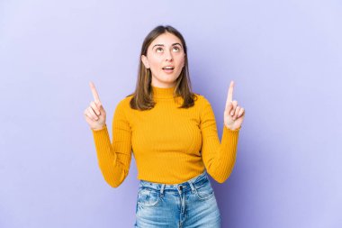 Kafkasyalı genç bir kadın ağzı açık bir şekilde üst tarafı işaret ediyor..