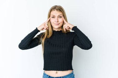 Beyaz arka planda izole edilmiş genç sarışın kadın bir işe odaklanmış, işaret parmaklarını işaret ediyor..