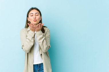 Beyaz kadın dudaklarını katlıyor ve hava öpücüğü vermek için avuçlarını tutuyor..