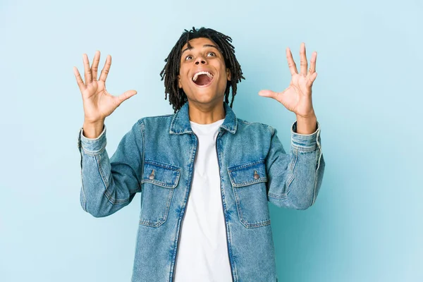 Kot ceket giyen genç siyah bir adam gökyüzüne bağırıyor, yukarı bakıyor, hayal kırıklığına uğramış..