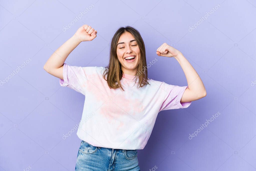 Young caucasian woman celebrating a special day, jumps and raise arms with energy.