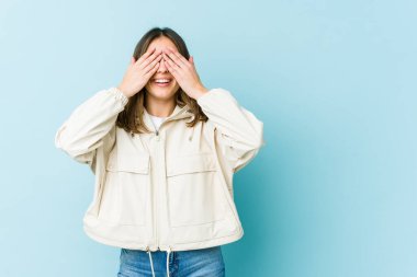 Kafkasyalı genç kadın elleriyle gözlerini kapatıyor, gülümseyerek bir sürpriz bekliyor..