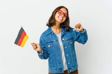 Beyaz arka planda izole edilmiş bir Alman bayrağı tutan genç Latin kadın gururlu ve kendinden emin hissediyor..
