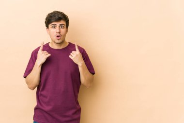 Genç havalı adam ağzı açık bir şekilde üst tarafı işaret ediyor..