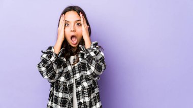 Genç, melez İspanyol bir kadın izole edilmiş, yüzünün yarısını avuç içiyle kaplayarak eğleniyor..