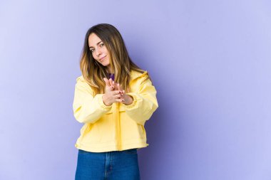 Mor arka planda izole edilmiş genç beyaz kadın enerjik ve rahat hissediyor, ellerini ovuşturuyor..