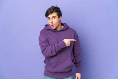 Genç havalı adam gülümsüyor ve boş alanda bir şeyler gösteriyor..