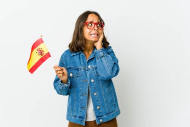 Genç İspanyol bir kadın beyaz arka planda izole edilmiş bir bayrak tutuyor kulakları kulaklarıyla örtüyor ve çok fazla ses duymamaya çalışıyor..