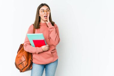 Beyaz arka planda izole edilmiş genç beyaz kadın yüksek sesle bağırıyor, gözleri açık ve elleri gergin tutuyor..