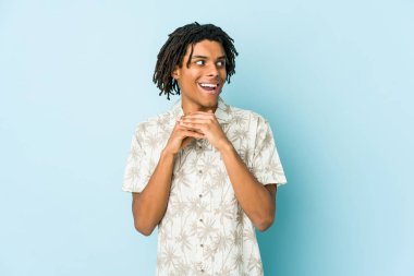 Afro-Amerikan Rasta 'lı genç adam şans için dua ediyor, şaşırmış ve ağzını açıyor..