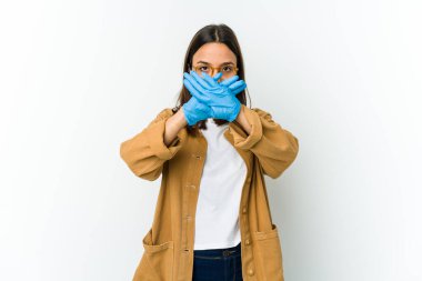 Maske takan genç Latin bir kadın beyaz arka planda izole edilmiş bir şekilde saklanıyor ve inkar hareketi yapıyor.