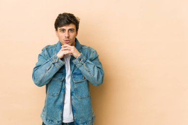 Genç havalı adam şans için dua ediyor, şaşırmış ve ağzını açıyor..