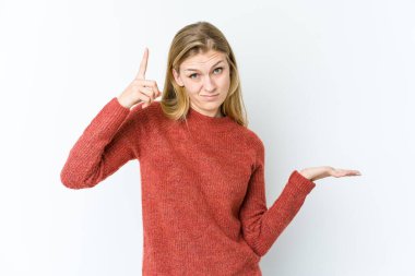 Beyaz arka planda izole edilmiş genç sarışın kadın elinde bir ürün tutuyor..