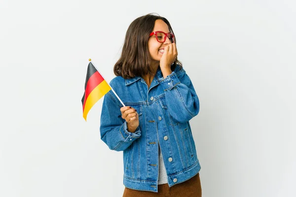 白地にドイツ国旗を掲げた若いラテン女性が何かを笑いながら口を手で覆い — ストック写真