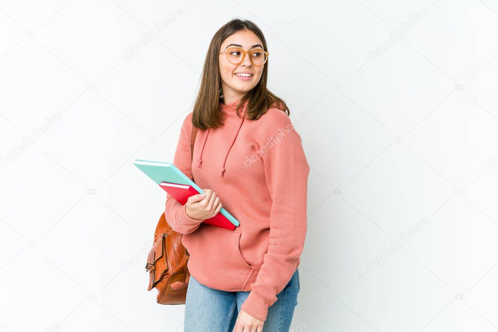 Young student woman isolated on white bakcground looks aside smiling, cheerful and pleasant.