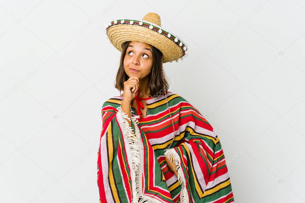 Young mexican woman isolated on white background looking sideways with doubtful and skeptical expression.