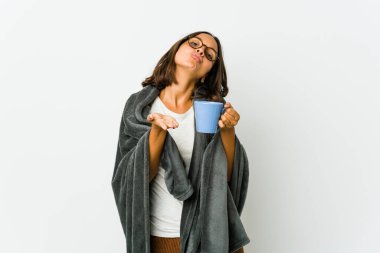 Beyaz arka planda izole edilmiş, dudakları kıvrılmış ve avuç içleriyle hava öpücüğü yollayan genç Latin bir kadın..