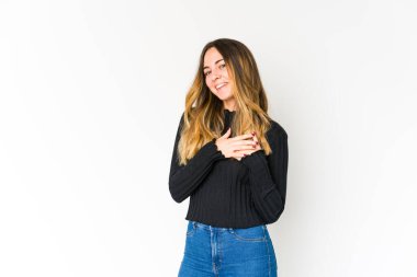 Beyaz arka planda izole edilmiş beyaz tenli genç bir kadın, dostane bir ifadeye sahip, avuçlarını göğsüne bastırıyor. Aşk konsepti.