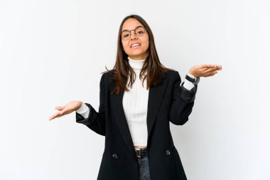 Beyaz arka planda soyutlanmış genç melez iş kadını kollarıyla ölçeği yapıyor, mutlu ve kendinden emin hissediyor..