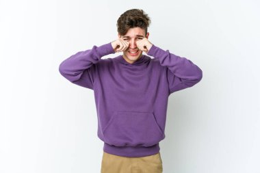 Beyaz arka planda ağlayan ve sızlanan beyaz tenli genç bir adam var..