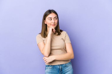 Şüpheli ve şüpheci bir ifadeyle yan bakan beyaz bir kadın..