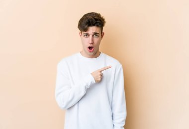 Beyazlı genç bir adam bej arka planda izole edilmiş.